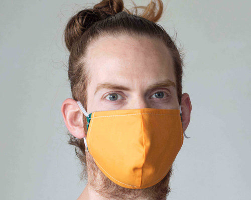 man wears orange washable face mask